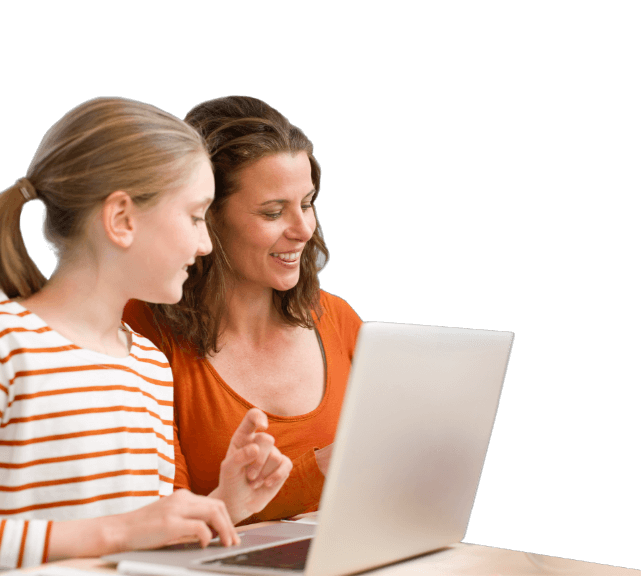 Smiling woman and girl sitting at a table looking at a laptop