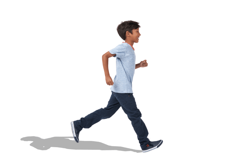 Smiling, young dark-haired boy in T-shirt and jeans striding across background