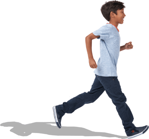 Smiling, young dark-haired boy in T-shirt and jeans striding across background