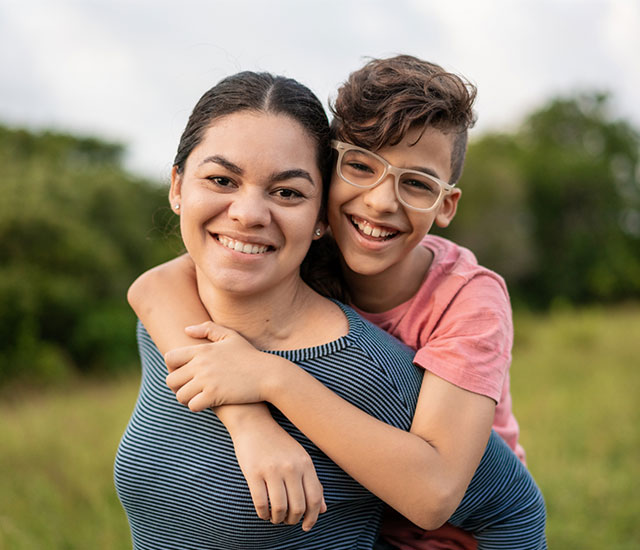 Photograph of a boy hugging a woman